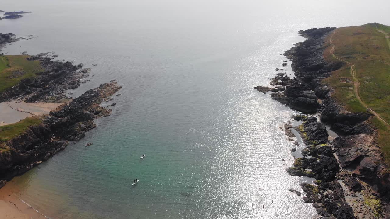 kayak costero galés: vista desde un avión no tripulado de kayaks cerca de acantilados en un día soleado