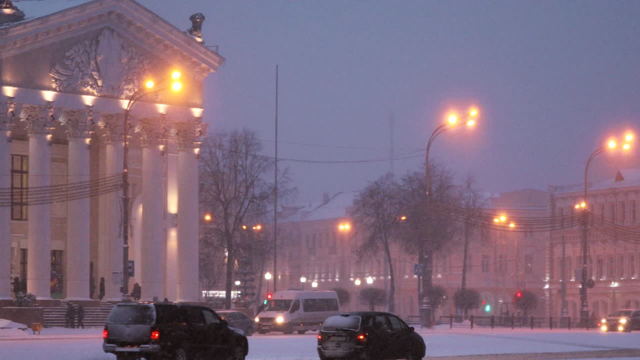 гомель, беларусь. здание гомельского регионального драматического театра на площади ленина зимой в снежную бурю вечернее время. паннорама, панорама
