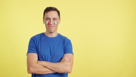 Man standing with italian flag painted on face smiling