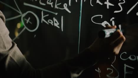 person writing on a glass board with marker