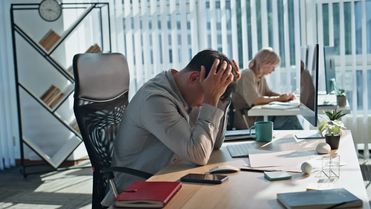 Confused man examining papers working on project at corporate workplace closeup