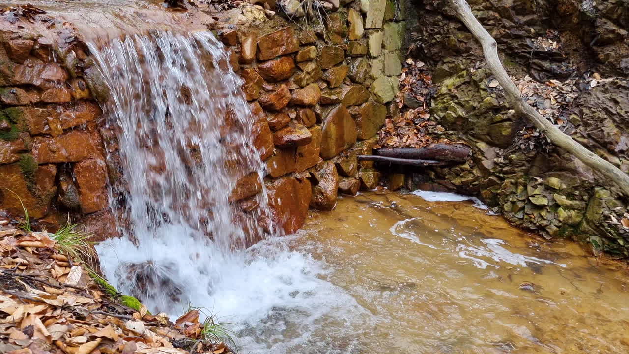 cascada de un arroyo de agua de riachuelo en el bosque en un día de invierno