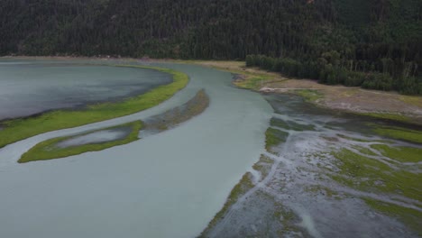 descending aerial drone with wide river and trees in deep valley in canada bc 4k