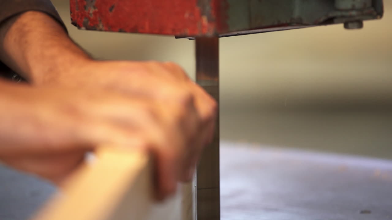 persona que utiliza una sierra de banda para cortar madera