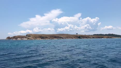 navegando y pasando por un pintoresco islote griego deshabitado en el mar mediterráneo en sithonia en 4k