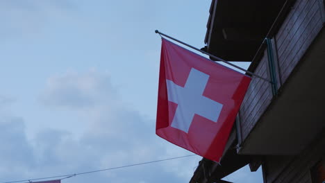 bandera suiza en el balcón de una casa en lauterbrunnen, suiza