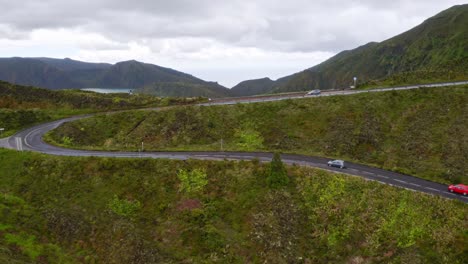 Coches-Circulando-Por-Una-Carretera-Serpenteante-Sobre-El-Lago-Lagoa-Di-Fogo,-Vistas-Elevadas