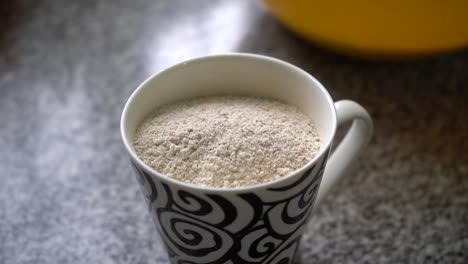 taza llena de nueces en polvo para hornear