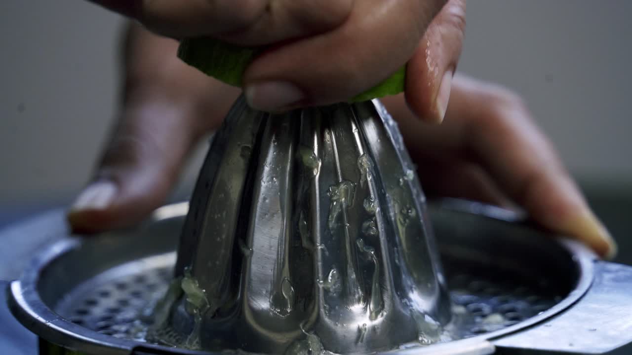 exprimir una rebanada de limón en un exprimidor de plata exprimir limones con el goteo a mano