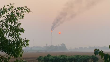 carbon emission concept, gas plant polluting environment, foggy sky covering sun