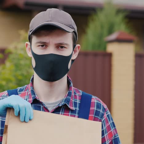 Portrait-Of-A-Courier-With-A-Bag-Of-Groceries-Stands-On-The-Street-In-The-Suburbs