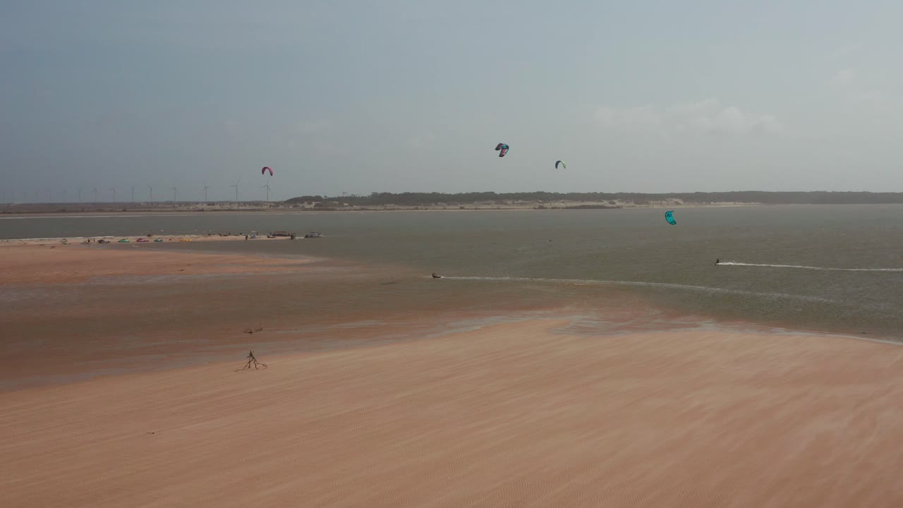 Kitesurfing on a Beautiful Beach with Wind Turbines