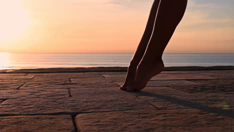 silhouetted legs and feet on a pier at sunset