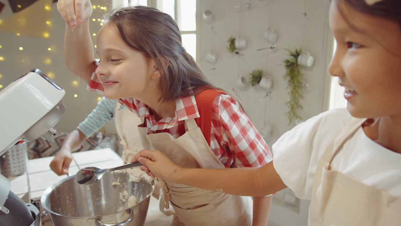 niños añadiendo harina al tazón del mezclador en la clase magistral de cocina