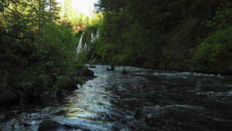Stream-water-flowing-off-Burney-Falls,-waterfall-in-California,-surrounded-by-forest