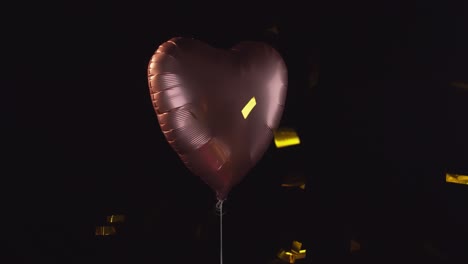 Lonely-pink-helium-balloon-with-gold-confetti-falling-across-the-scene