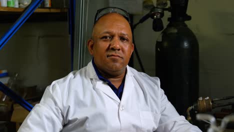 vista frontal de un trabajador masculino maduro sentado en un escritorio en una fábrica de vidrio 4k
