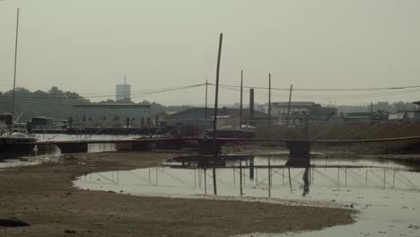 a lone man walking over a bridge towards a river dock in an urban area on a hot summer day