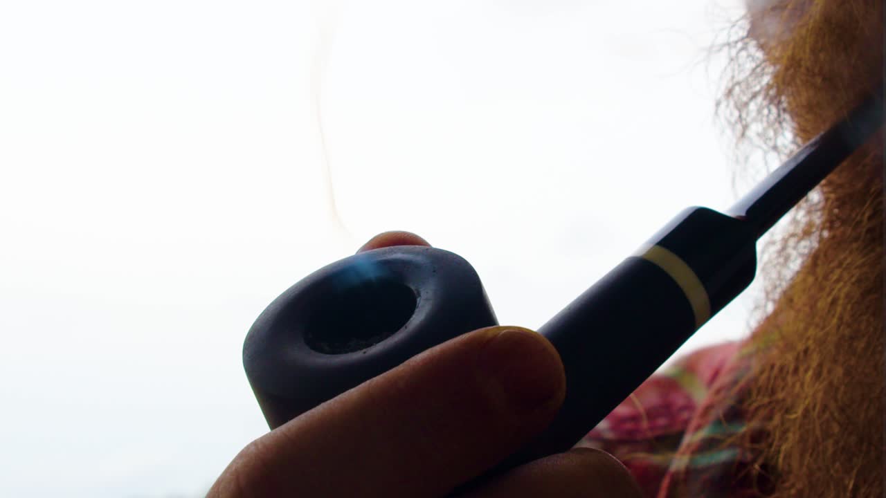 휴식 시간: 야외에서 담배를 피우고, 우리의 조상들이 했던 것처럼 검은색의 옛날의 빈티지 파이프, 담배를 태우고, 맛의 달함을 즐기는 올바른 방법, 장기적인 건강 위험을 가져올 수 있습니다.