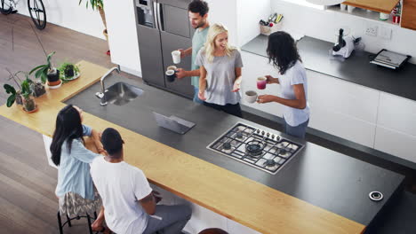 overhead view of friends drinking coffee in modern kitchen