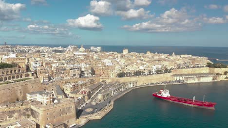 Aerial-shot-over-an-old-city-surrounded-with-sea-and-a-harbour