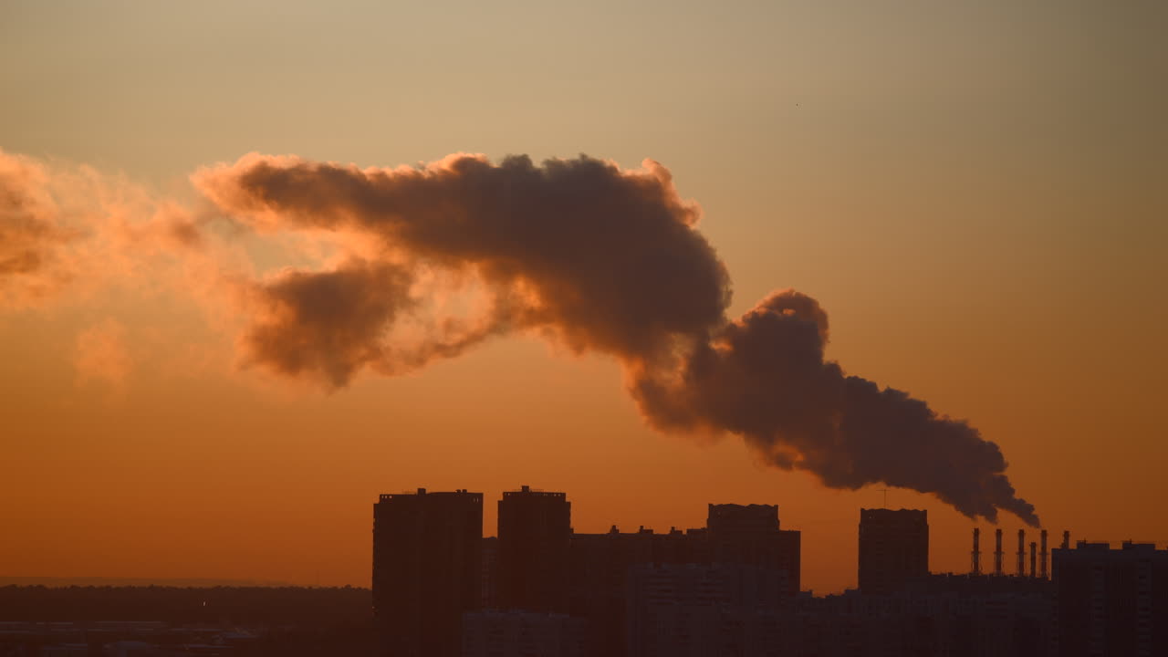 Camini industriali che rilasciano fumo sopra lo skyline della città al tramonto Emissioni industriali urbane Inquinamento atmosferico Cielo serale Area metropolitana Inquinamento atmosferico e attività industriale Nuvole di fumo Ambientale
