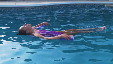 Niña-Relajándose-En-Una-Piscina-Sobre-Un-Fideo