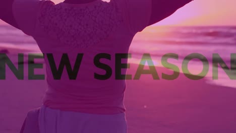 animation of new season text over woman standing with arms outstretched by sea with pink tint