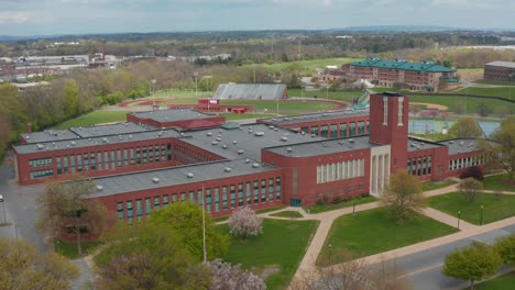 rising aerial reveals large red brick academic school university building exterior