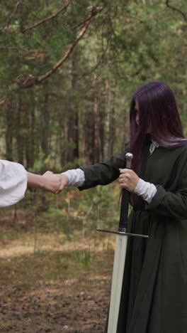 girls shake hands before sword fight, historical reconstruction, medieval period