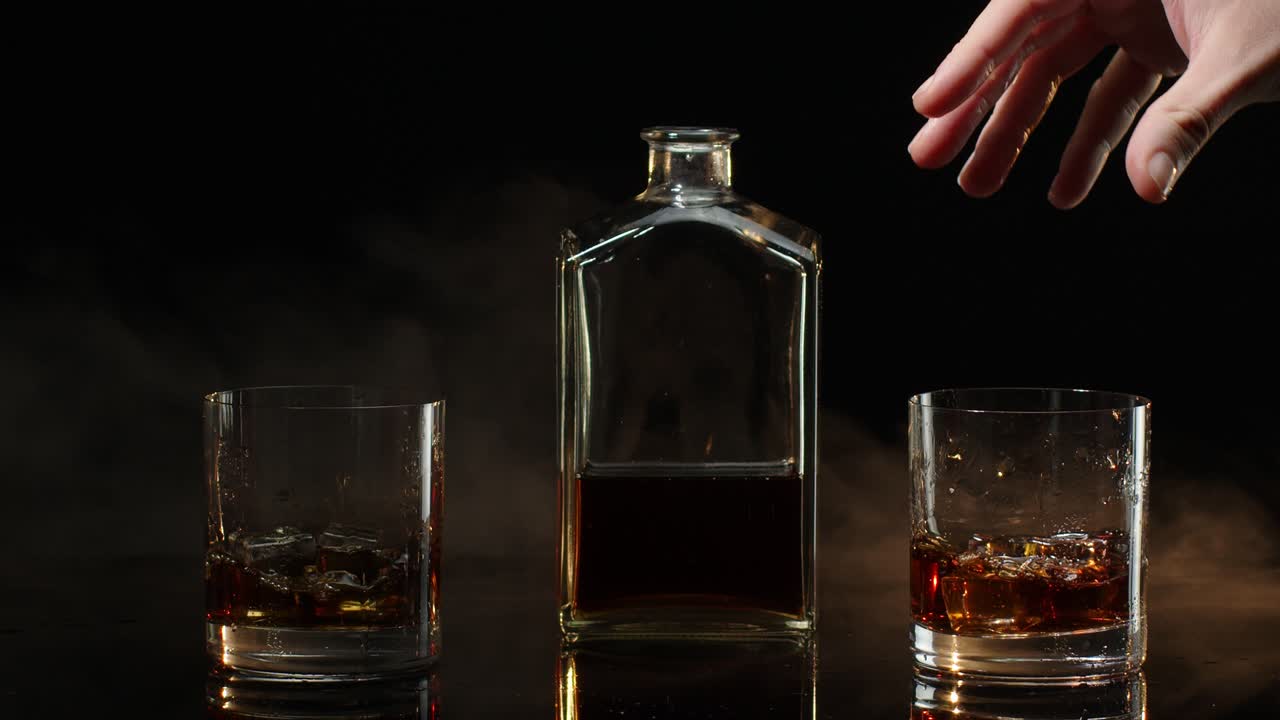 dos personas brindando con vasos de whisky