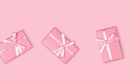 many rectangular gift boxes with ribbon and bow close-up against a pink background, seamless looping animation