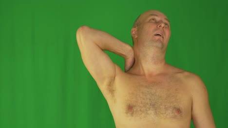 man rubbing stroking his neck and shoulders with left hand. front view naked waist up.