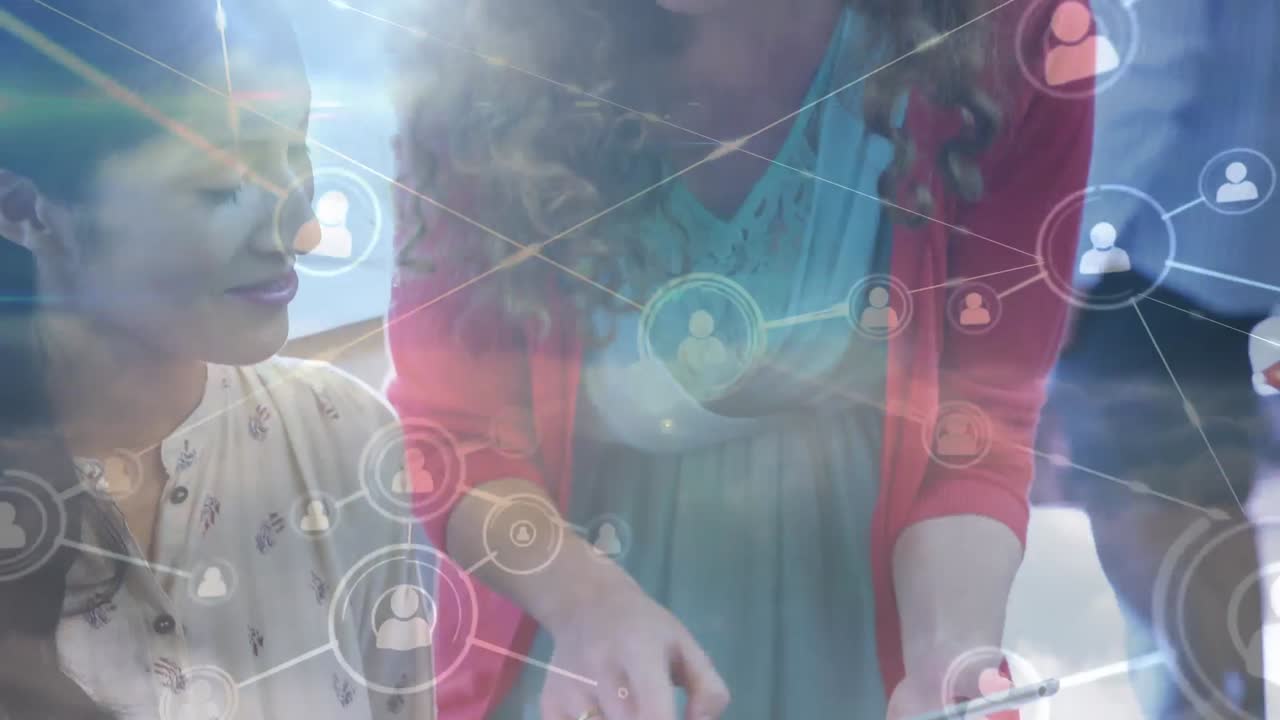 animación de una red de iconos de perfil sobre dos mujeres diversas discutiendo sobre una tableta digital