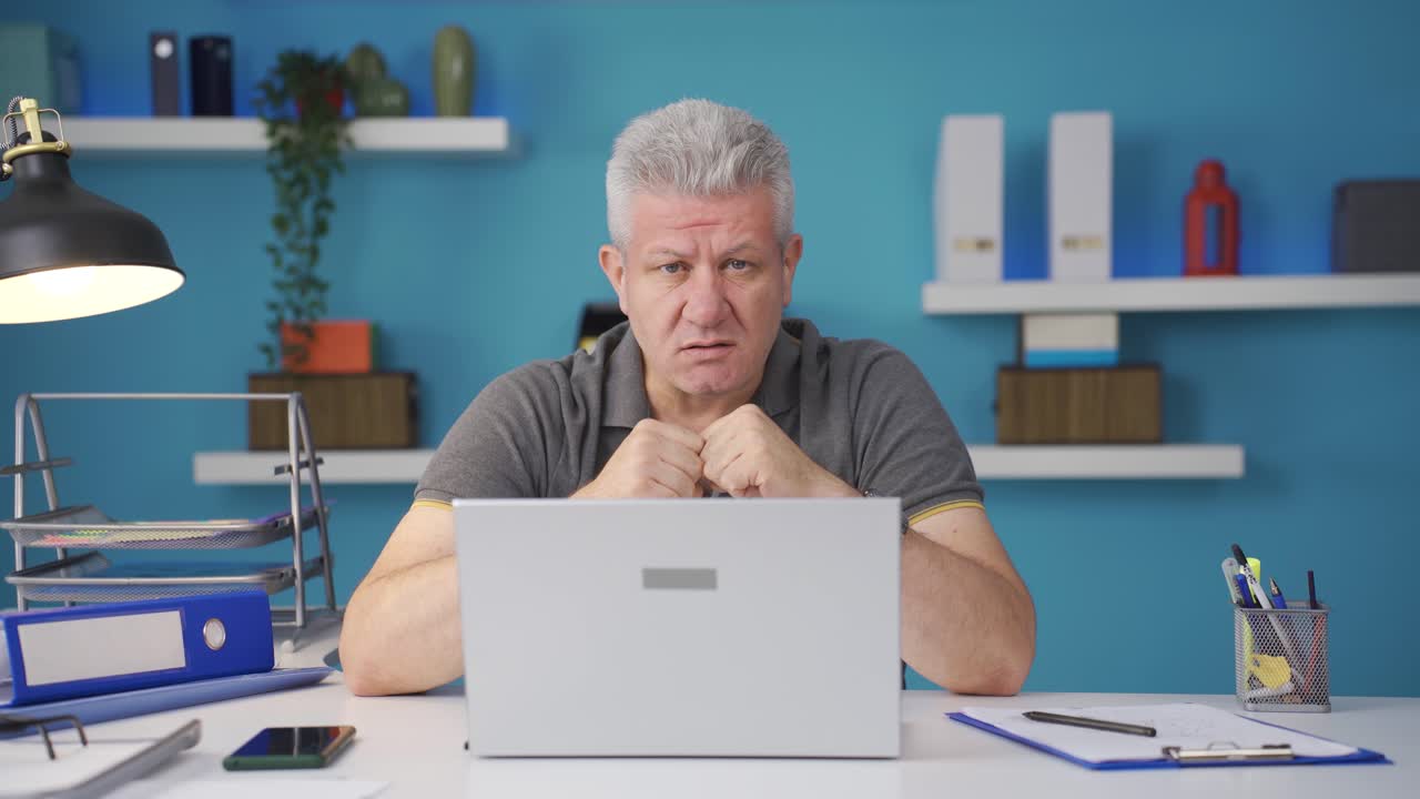 trabajador de oficina en casa hombre mirando a la cámara confundido.