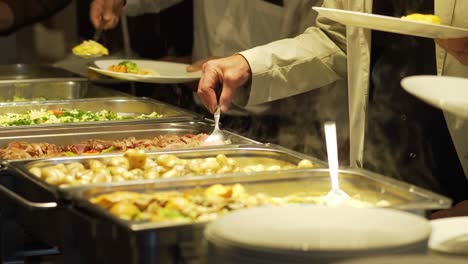 los huéspedes del restaurante eligen la comida de un buffet