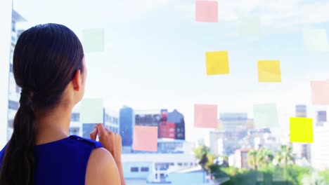 Woman-taking-notes-on-office-window