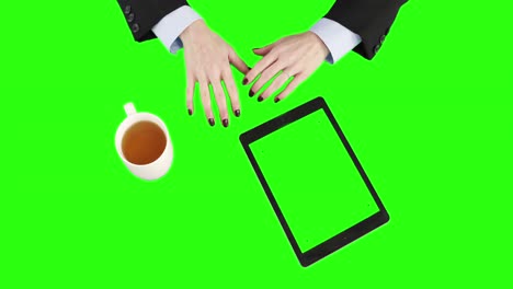 Overview-of-a-businesswoman-using-a-tablet-and-holding-a-cup-of-coffee-while-talking