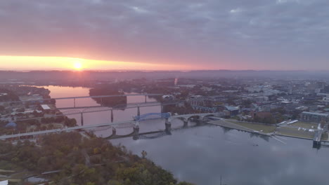 Wide-aerial-footage-in-the-morning-during-sunrise-backing-up-revealing-more-of-the-Tennessee-River-and-downtown-Chattanooga,-Tennessee