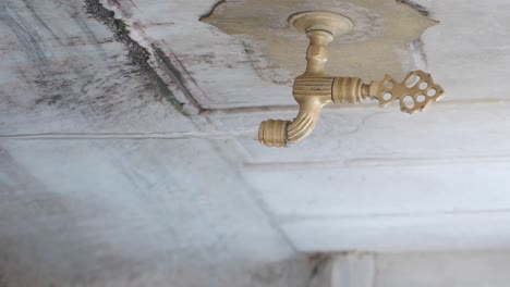 water flowing from an antique brass faucet