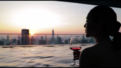 a tranquil evening by the pool: enjoying the sunset view over the city with a glass of wine, perfect for relaxation and reflection