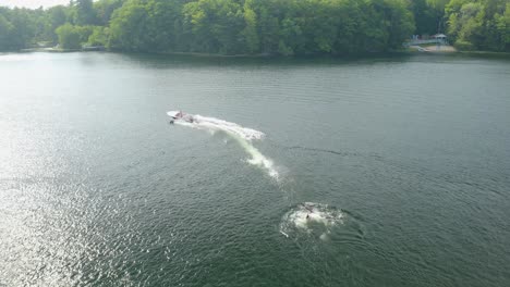 a person is pushed behind a boat while participating in the surface water sport of water skiing, also known as waterskiing or water-skiing