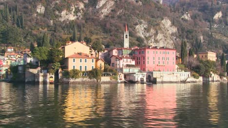 POV-from-a-boat-of-the-shores-of-Lake-Como-with-the-town-of-Varenna-and-the-Italian-Alps-in-background-1