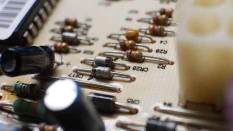 muchas resistencias, condensadores y componentes electrónicos en un antiguo controlador de placa de circuito retro