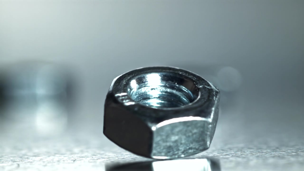 Close-up de uma Porca Sextavada de Metal Girando em uma Superfície