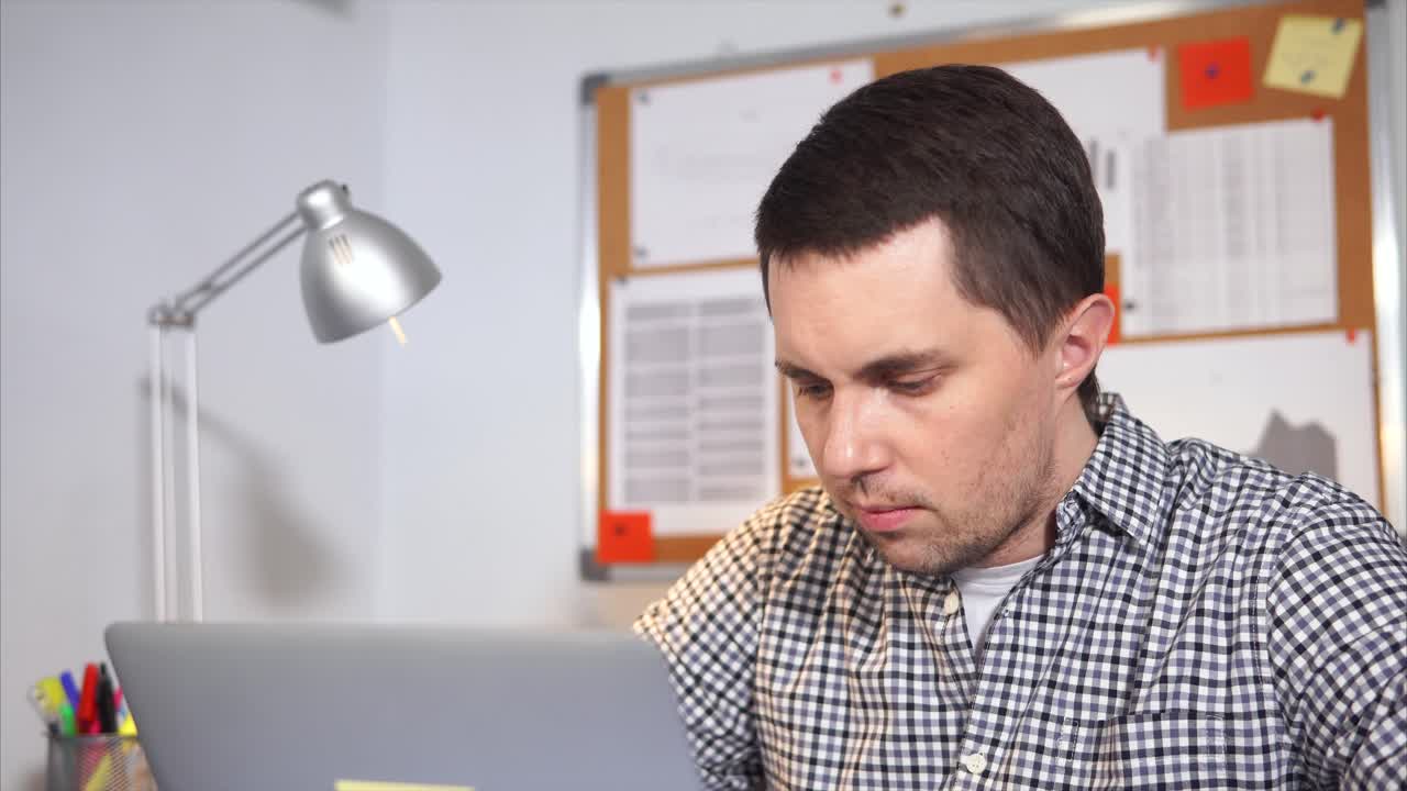 Hombre que trabaja en la computadora portátil en la oficina