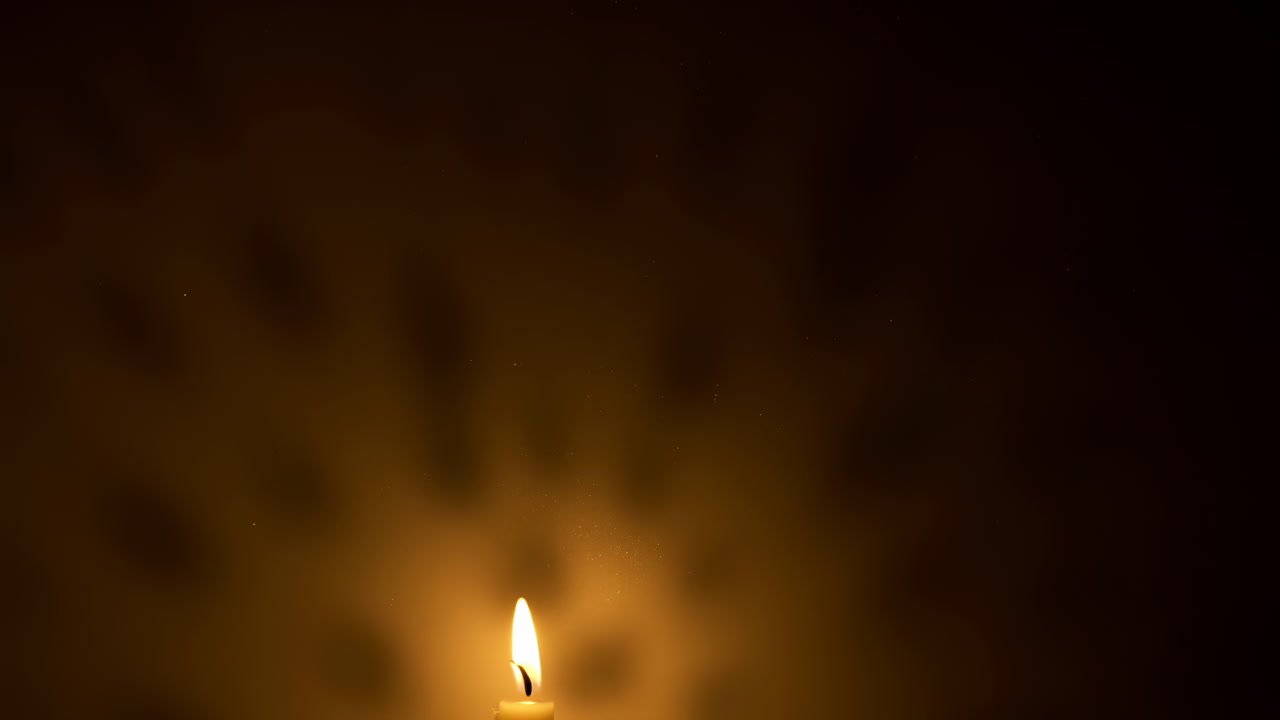 Solitary Candle Flame Glowing In Darkness, Warm Amber Light Casts Soft Shadows On Blurred Background, Gentle
