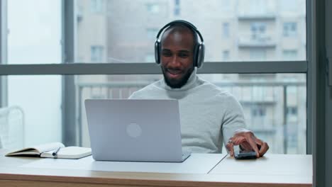 man working on laptop with headphones