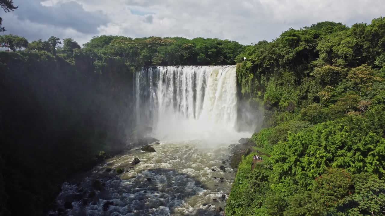 toma aérea de reenvío de drones que muestra una cascada que atraviesa un bosque mexicano con una exuberante vegetación verde en un día soleado