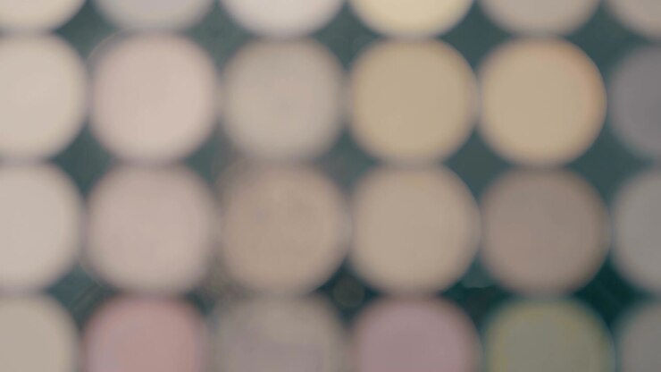 Make-up brushes laying on colorful cosmetic palette. Camera rotation